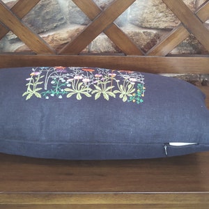 Peut inclure: Un coussin bleu fonc&eacute; avec une fermeture &eacute;clair pr&eacute;sente un motif brod&eacute; de fleurs et de feuilles color&eacute;es.