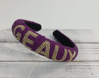 Diadema Geaux con cuentas, color morado y dorado.