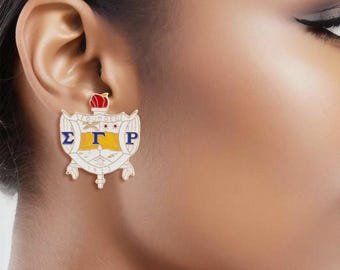 Pendientes de botón con el escudo de la hermandad Sigma Gamma Rho en azul y dorado (orejas perforadas)