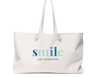 May include: White canvas tote bag with rope handles and a blue and green gradient "smile like sunshine" graphic.