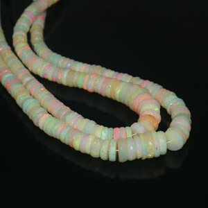 May include: Strands of opal beads in a variety of shapes and sizes. The beads have a milky white base color with flashes of iridescent color. The beads are strung together, creating a necklace or bracelet.