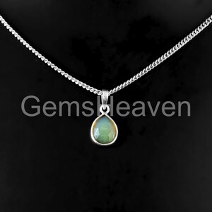 May include: A silver necklace with a pear-shaped, light green gemstone pendant. The pendant is set in a silver bezel and hangs from a delicate chain. The text "GemsHeaven" is visible in the image.