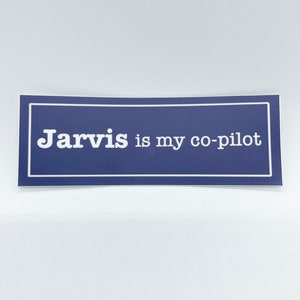 May include: A blue rectangular sticker with a white border and white text that reads "Jarvis is my co-pilot".