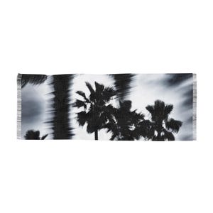 May include: A black and white rectangular scarf featuring a palm tree silhouette design. The scarf has a fringed edge and a blurred effect, creating a dreamy, artistic aesthetic. The palm trees are set against a cloudy sky.