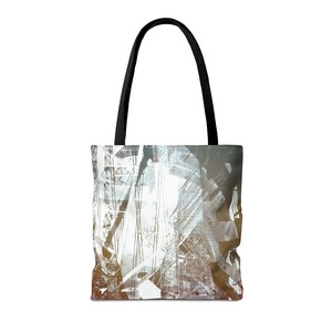 May include: A white tote bag with black handles. The bag features a graphic design of a city skyline in shades of grey, brown, and white.