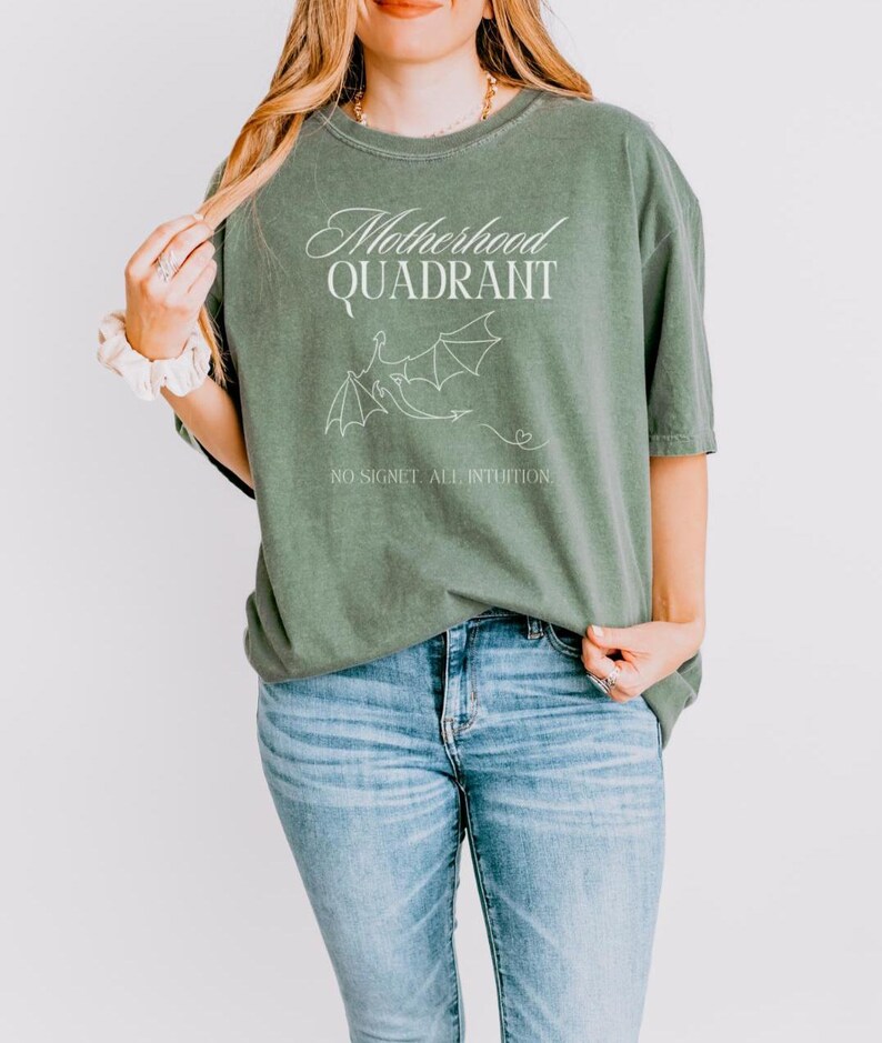 A model wears a comfort colors shirt in moss green. It is inspired by Fourth Wing merch