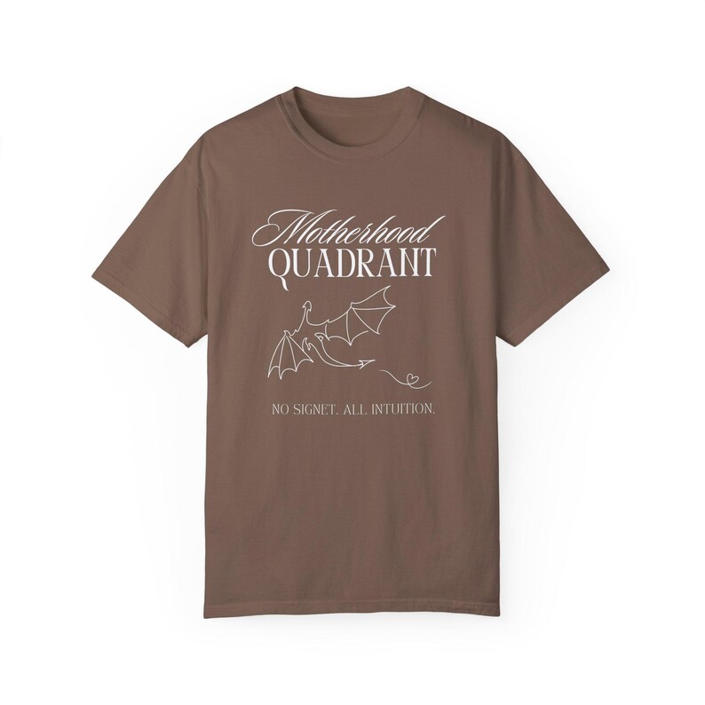 A flat lay photo of a comfort colors shirt in espresso. The shirt is inspired by Fourth Wing and has a dragon on the front along with the wording, Motherhood Quadrant No signet. All intuition. It would be a perfect gift for moms who love to read