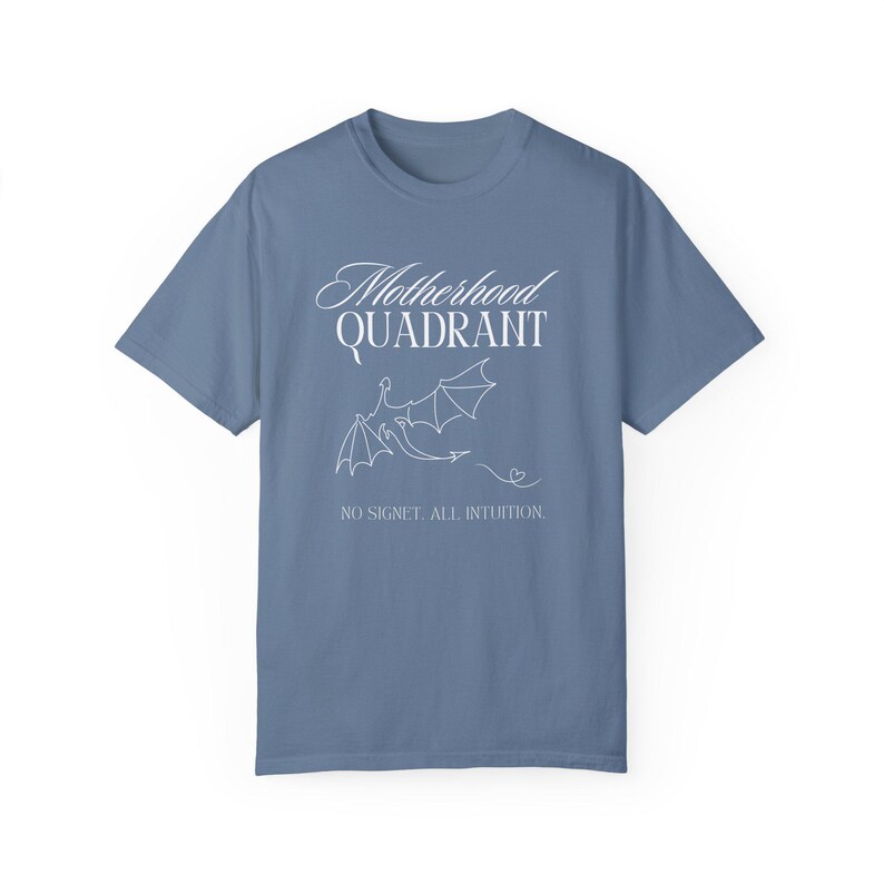 A flat lay shirt in denim blue. It says Motherhood Quadrant and is inspired by the Fourth Wing Series
