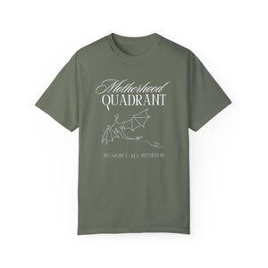 A flat lay of a moss green comfort colors shirt that has a flying dragon on it. It also says Motherhood Quadrant and has a flying dragon. It would be a perfect gifts for moms who like to read, and Fourth Wing