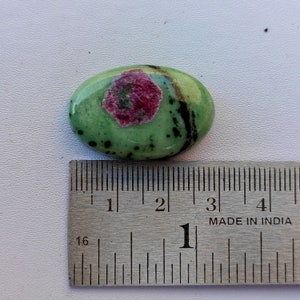 Peut inclure: Pierre pr&eacute;cieuse ovale verte avec un centre rose et noir, mesurant environ 2,5 cm de long, &agrave; c&ocirc;t&eacute; d'une r&egrave;gle.