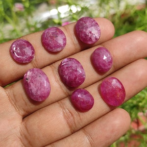 Pu&ograve; includere: Otto pietre preziose ovali sfaccettate di colore rosa. Le pietre preziose sono disposte in una mano, con la pietra pi&ugrave; grande al centro.