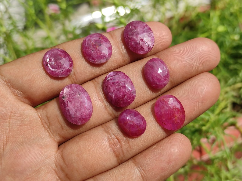 Pu&ograve; includere: Otto pietre preziose ovali sfaccettate di colore rosa. Le pietre preziose sono disposte in una mano, con la pietra pi&ugrave; grande al centro.