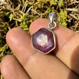 Könnte beinhalten: Ein sechseckiger Anhänger mit einem rosafarbenen und violetten Edelstein, der in Sterlingsilber gefasst ist.