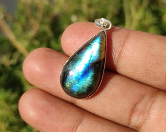 Può includere: Un ciondolo a forma di lacrima con una montatura in argento e una pietra preziosa in labradorite blu e verde.