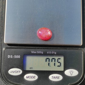 K&ouml;nnte beinhalten: Ein rosa Edelstein mit einem Gewicht von 7,75 Karat auf einer digitalen Waage. Die Waage zeigt "Max:500g d:0.01g" und "DS-500".