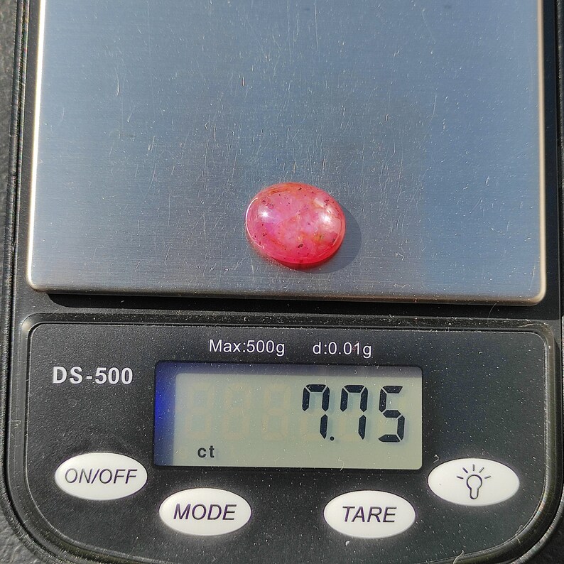 K&ouml;nnte beinhalten: Ein rosa Edelstein mit einem Gewicht von 7,75 Karat auf einer digitalen Waage. Die Waage zeigt "Max:500g d:0.01g" und "DS-500".