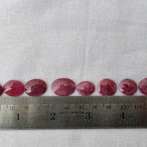 Pu&ograve; includere: Dieci pietre preziose ovali sfaccettate, che vanno da 2,5 a 3,8 cm di diametro, sono allineate su un righello. Le pietre preziose sono di colore rosa intenso.