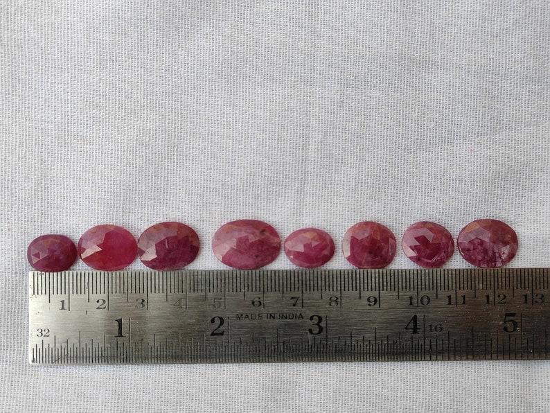 Pu&ograve; includere: Dieci pietre preziose ovali sfaccettate, che vanno da 2,5 a 3,8 cm di diametro, sono allineate su un righello. Le pietre preziose sono di colore rosa intenso.