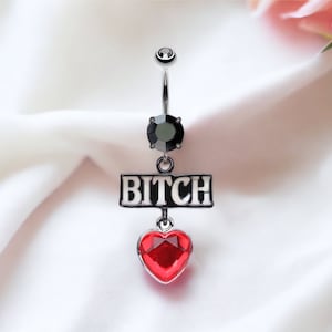 May include: A silver body piercing with a black gem, a red heart charm, and a silver charm with the word "BITCH" in white letters.