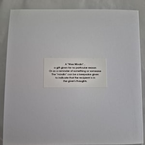 May include: A white card with black text explaining the meaning of a "Wee Mindin". A "Wee Mindin" is a gift given for no particular reason or as a reminder of something or someone. The "mindin" can be a keepsake given to indicate that the recipient is in the giver's thoughts.