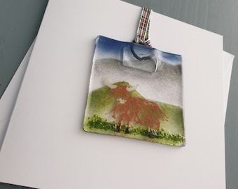 A "Wee Mindin" card and detachable Highland Coo hanging