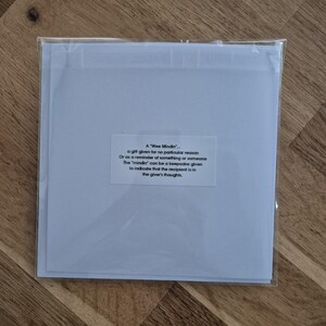May include: A white card with a blue border and a text box that reads "A 'Wee Mindin' - a gift given for no particular reason Or as a reminder of something or someone The 'mindin' can be a keepsake given to indicate that the recipient is in the giver's thoughts."