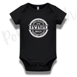 Peut inclure: Un body pour bébé noir à manches courtes avec un motif circulaire blanc sur la poitrine. Le design comprend le texte "RESPECT THE CULTURE", "HAWAIIAN", "BUILT" et "NEVER FORGET YOUR ROOTS" avec un symbole infini en haut au centre.