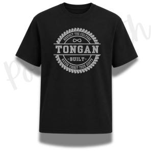 Peut inclure: Un t-shirt noir à manches courtes avec un motif circulaire gris. Le design comprend le texte "TONGAN" au centre, "RESPECT THE CULTURE" au-dessus, "NEVER FORGET YOUR ROOTS" en dessous, et "BUILT" au milieu avec un symbole infini.