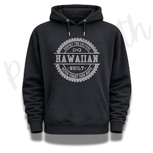 Peut inclure: Un sweat-shirt à capuche noir avec un motif circulaire gris sur la poitrine. Le design comprend le texte "RESPECT THE CULTURE", "HAWAIIAN", "BUILT" et "NEVER FORGET YOUR ROOTS", ainsi qu'un symbole infini et une bordure en forme d'engrenage.