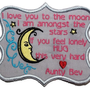 May include: A grey embroidered patch with a crescent moon and stars. The text reads "I love you to the moon I am amongst the stars If you feel lonely HUG this very hard Aunty Bev".