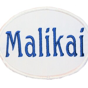 May include: White oval-shaped patch with blue embroidered lettering that reads "Malikai".