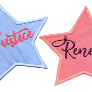 May include: Two star-shaped fabric patches with embroidered names. The blue patch has the name "Justice" in pink lettering. The pink patch has the name "Renelle" in purple lettering.