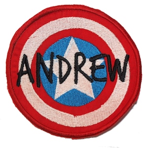 May include: Red, white and blue embroidered patch with a star and the name "ANDREW" in black.