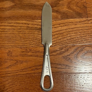 May include: A silver metal knife with a pointed tip and a handle marked "U.S."