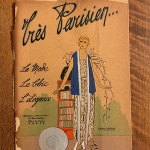 May include: Vintage magazine cover titled "Très Parisien" featuring an illustration of a woman in a patterned dress and blue shawl. The cover includes text in French, with the words "La Mode, Le Chic, L'élégance". The magazine is from June 1933.