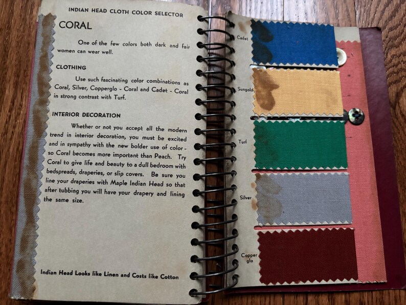 May include: A vintage color selector guide for Indian Head cloth, featuring the color coral. The guide includes a description of the color and its uses in clothing and interior decoration. The page also shows swatches of different colors, including cadet, sangold, turf, silver, and copperglo.
