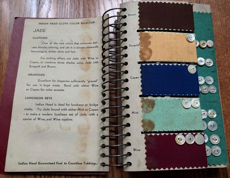 May include: A color selector guide for Indian Head cloth, featuring swatches of fabric in various colors, including jade, brown, sungold, copen, mint, and wine. The guide includes text describing the uses and properties of each color.