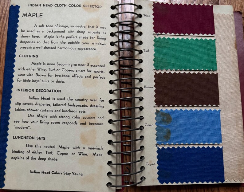 May include: A color chart for Indian Head Cloth, showing the color "Maple" and its suggested uses for clothing, interior decoration, and luncheon sets. The chart also shows the colors Wine, Turf, Brown, Coma, and Copen.