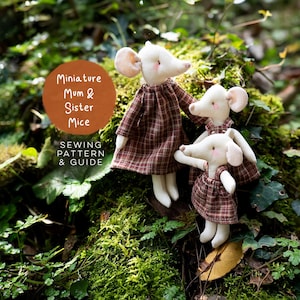 May include: Two white fabric mouse dolls wearing brown plaid dresses. The larger mouse stands behind the smaller one. A circular orange graphic features the white text: Miniature Mum & Sister Mice SEWING PATTERN & GUIDE.