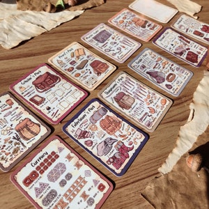 May include: A set of ten illustrated cards featuring different character classes and their associated equipment. Each card has a title, for example, "Scholar's Pack" or "Entertainer's Pack", and a detailed illustration of the character's gear. The cards are printed on a cream-coloured background with brown accents.