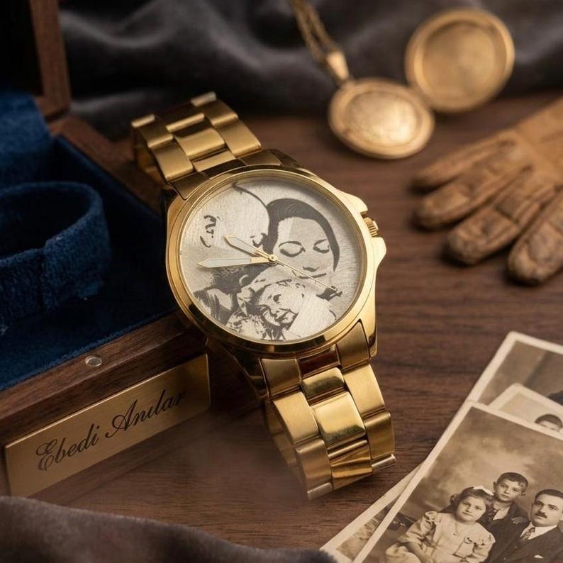 May include: A gold-toned wristwatch with a personalized photo on the watch face. The watch has a matching gold band and is displayed with a wooden box, vintage photos, and a gold pendant. The watch face features a black and white image of a family.