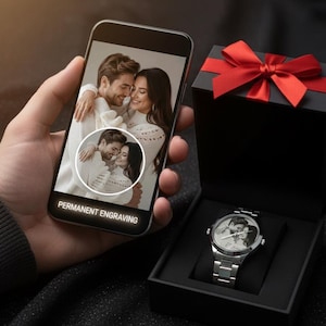 May include: A silver wristwatch with a photo of a couple on the watch face, displayed in a black gift box with a red bow. A smartphone shows the same photo with the text "PERMANENT ENGRAVING".