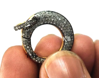May include: A silver and gold round clasp with a small diamond-like design. The clasp is open and ready to be attached to a necklace or bracelet.
