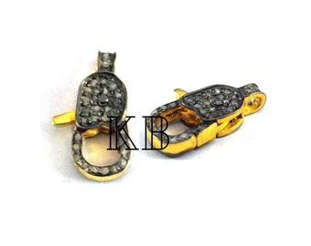 May include: Two gold-toned metal clasps with a silver finish, each encrusted with small, clear diamonds. The clasps are designed for jewelry making.