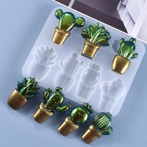 May include: A silicone mould with 10 different shapes of cacti and succulents. The mould is light blue and has a smooth surface. The cacti and succulents are in various shades of green.