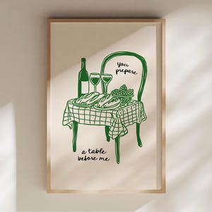 Könnte beinhalten: Ein gerahmter Kunstdruck mit einer grünen Strichzeichnung eines Tisches, der für eine Mahlzeit gedeckt ist. Der Tisch hat eine karierte Tischdecke und hält Brot, Trauben, Weingläser und eine Weinflasche. Die Worte "you prepare a table before me" sind auf dem Druck geschrieben.