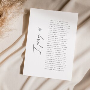 May include: A white card with a handwritten inscription "I pray" and a passage from Ephesians 3:16-21. The text reads: "That out of His glorious riches He may strengthen you with power through His Spirit in your inner being, so that Christ may dwell in your hearts through faith. And I pray that you, being rooted and established in love, may have power, together with all the Lord's holy people, to grasp how wide and long and high and deep is the love of Christ, and to know this love that surpasses knowledge&mdash;that you may be filled to the measure of all the fullness of God. Now to Him who is able to do immeasurably more than all we ask or imagine, according to His power that is at work within us, to Him be glory in the church and in Christ Jesus throughout all generations, for ever and ever. Amen. Ephesians 3:16-21"
