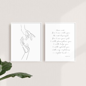 May include: Two black and white prints, one with a line drawing of two hands reaching towards each other, and the other with a quote from Isaiah 41:10, "Fear not, for I am with you; be not dismayed, for I am your God. I will strengthen you and help you; I will uphold you with my righteous right hand."