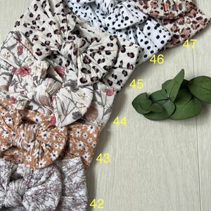 Op de afbeelding: Een set van zes stoffen hoofdbanden met verschillende patronen, waaronder bloemen, luipaardprint en stippen. De hoofdbanden zijn in een stapel gerangschikt, met de nummers 42 tot en met 47 zichtbaar aan de rechterkant van de afbeelding.
