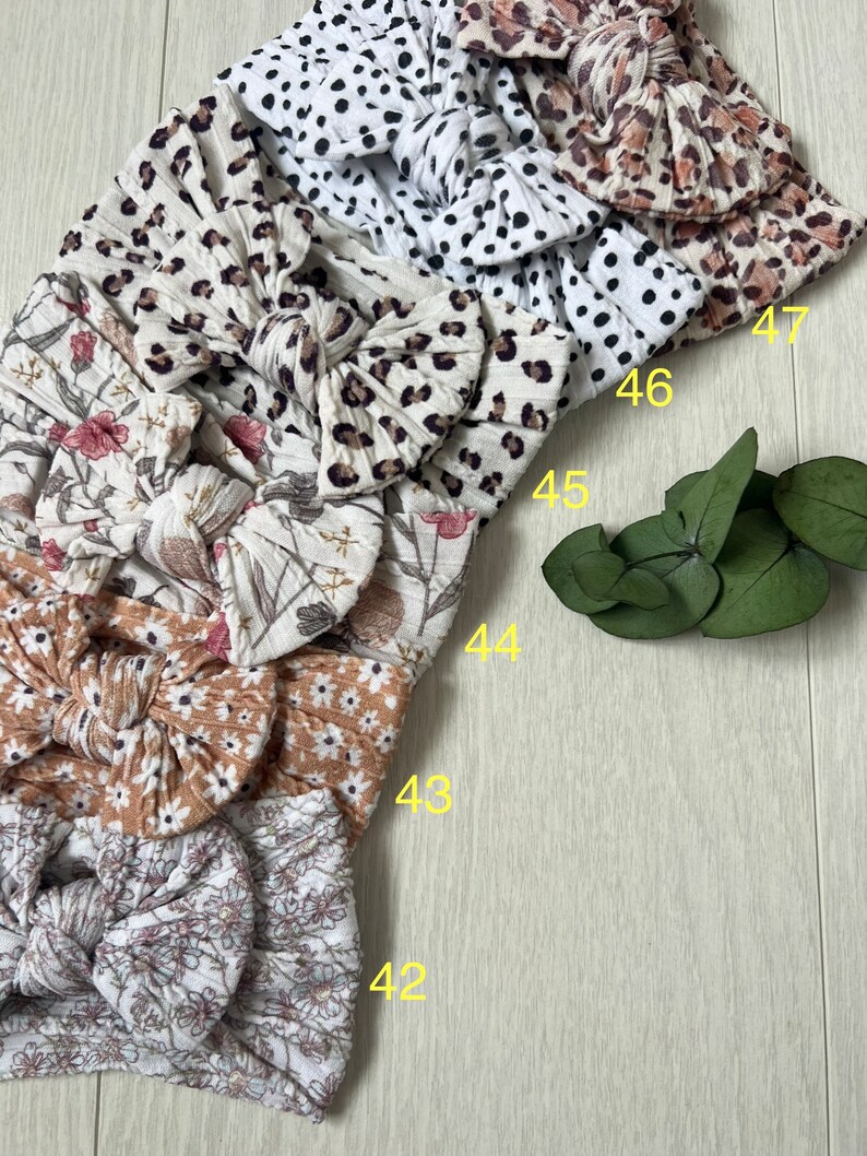 Op de afbeelding: Een set van zes stoffen hoofdbanden met verschillende patronen, waaronder bloemen, luipaardprint en stippen. De hoofdbanden zijn in een stapel gerangschikt, met de nummers 42 tot en met 47 zichtbaar aan de rechterkant van de afbeelding.